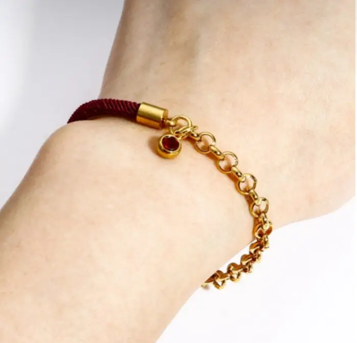 This elegant bracelet features a delicate gold chain and a charm, adding a touch of sophistication to any outfit. Perfect for both casual and formal occasions, this accessory is a must-have for anyone looking to add a subtle pop of color to their ensemble. Made with high-quality materials, this bracelet is durable and long-lasting, making it a timeless addition to your jewelry collection