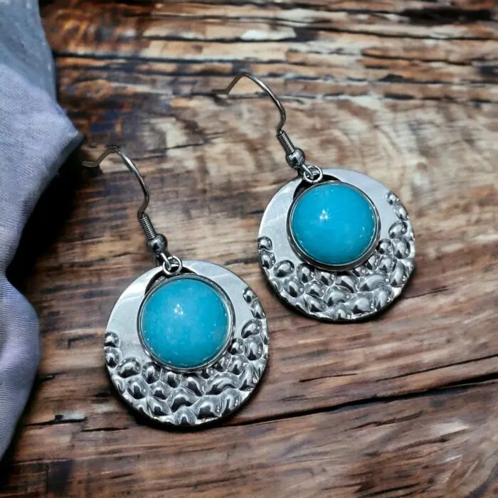 These stunning silver and turquoise earrings featuring a chic circular design with a popcorn pattern. Crafted from durable stainless steel and adorned with beautiful jade stones, they offer a perfect blend of elegance and modern flair