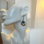 Crafted from durable stainless steel, these Silver Dangling earrings featuring a unique  abalone shell in bezel setting