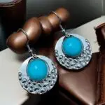 These stunning silver and turquoise earrings featuring a chic circular design with a popcorn pattern. Crafted from durable stainless steel and adorned with beautiful jade stones, they offer a perfect blend of elegance and modern flair