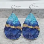 These stunning blue and gold marble teardrop earrings! Made from lightweight PU leather, they offer a chic look without the heavy feel. Perfect for adding a pop of color to any outfit, these earrings are a must-have for fashion lovers who appreciate unique designs.